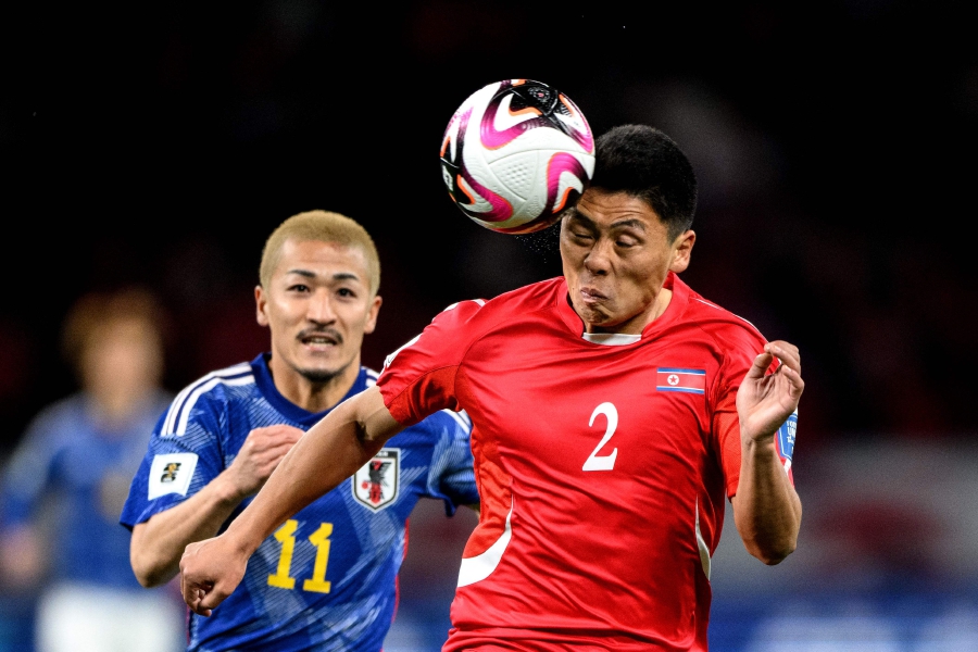 North Korea's defender Kim Kyong Sok and Japan's Daizen Maeda (L) compete for the ball during the World Cup 2026 qualifier football match between Japan and North Korea at the National Stadium in Tokyo on March 21, 2024. -AFP PIC