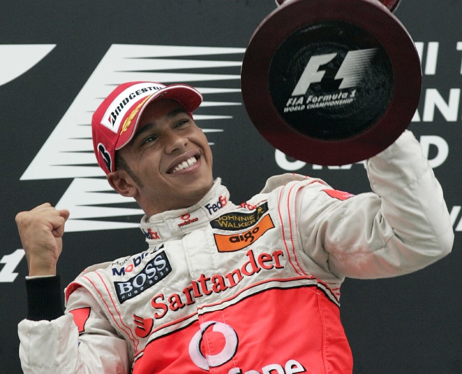 (FILES) Formula One drivers point leader Lewis Hamilton of Great Britain looks at his winning trophy on the podium after victory in the rain-affected Japanese Formula One Grand Prix at the Fuji Speedway in 2007. (Photo by TOSHIFUMI KITAMURA / AFP)