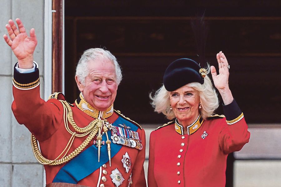 (FILES) Britain's King Charles III and Britain's Queen Camilla wave from the balcony of Buckingham Palace after attending the King's Birthday Parade, 'Trooping the Colour', in London. (Photo by Adrian DENNIS / AFP)