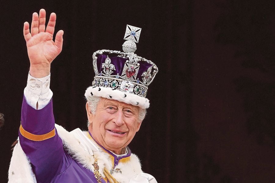 (FILES) Britain's King Charles III wearing the Imperial state Crown, waves from the Buckingham Palace balcony after viewing the Royal Air Force fly-past in central London, after his coronation. (Photo by Stefan Rousseau / POOL / AFP)