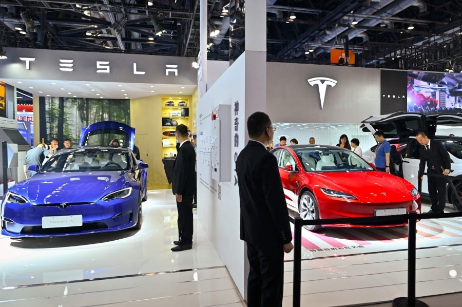 People visit a Tesla stall at the China International Fair for Trade in Services (CIFTIS) in Beijing on September 4, 2023. Tesla is recalling more than 1.6 million electric vehicles in China, the country's market regulator said on January 5, 2024, owing to software issues that could pose safety risks while driving. AFP FILE PIC