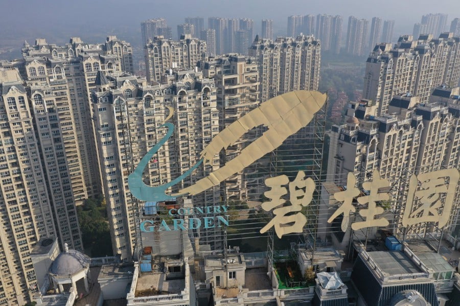 (FILES) This aerial photo taken on October 31, 2021 shows a logo of Chinese property developer Country Garden on top of a building in Zhenjiang in China's eastern Jiangsu province. China's troubled property giant Country Garden said August 16, 2023 there were "major uncertainties" over payments on its bonds, with fears swirling about a potentially catastrophic default by the company in September. (Photo by AFP) / China OUT