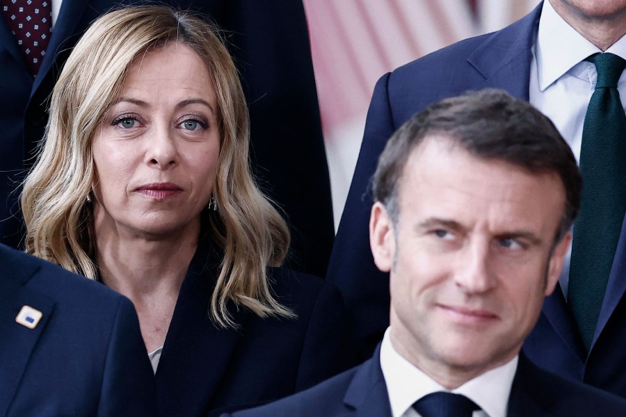 Italy's Prime Minister Giorgia Meloni (L) looks on behind France's President Emmanuel Macron prior to a family photo with leaders mingle, members of the European Council and the Prime Ministers at the EU headquarters, on the occasion of the 30th anniversary of EEA, in Brussels, on March 22, 2024. AFP FILE PIC