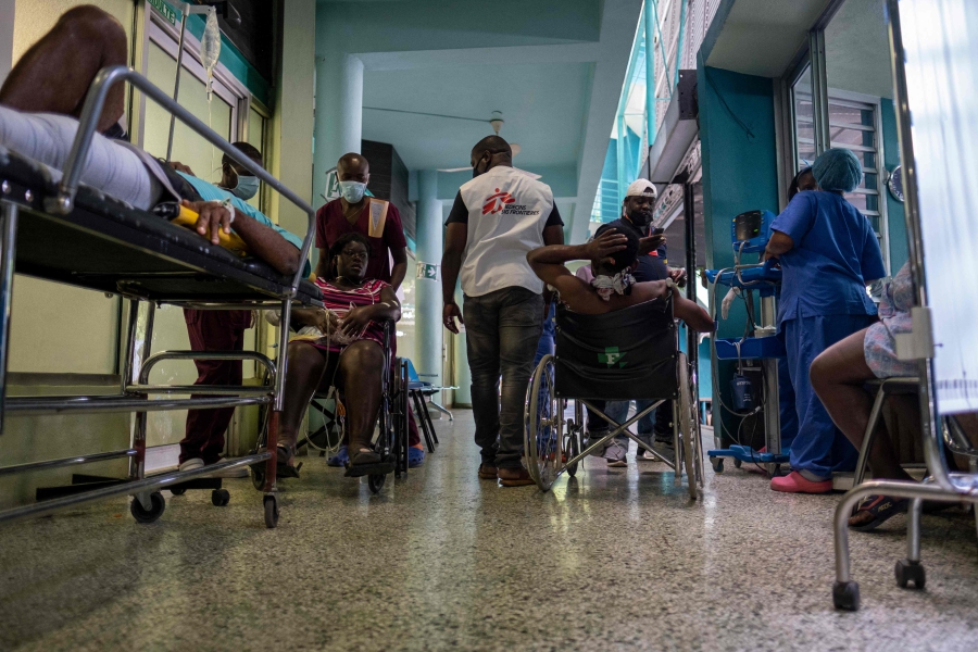 (FILES) Patients wait outside the triage area of a Doctors Without Borders medical facility during a general strike and lack of transportation, amid a fuel shortage in Port-au-Prince, Haiti. (Photo by Ricardo ARDUENGO / AFP)