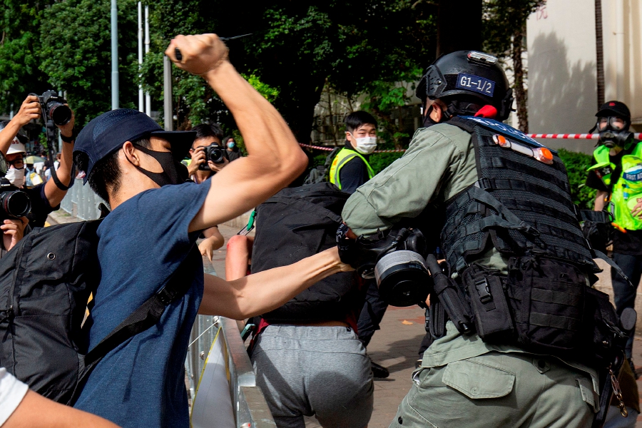 A protester (L) using a sharp object against a police officer (R) who is trying to detain a man (C) during a rally against a new national security law in Hong Kong on the 23rd anniversary of the city's handover from Britain to China. -File pic via AFP 