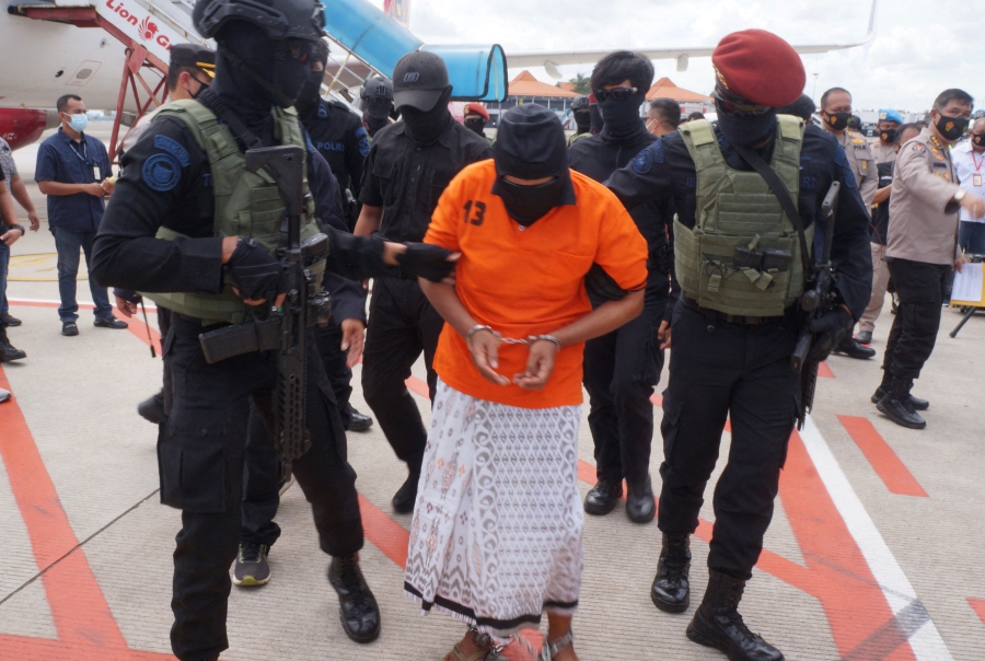 (FILES) This file photo taken on December 16, 2020 shows police escorting Zulkarnaen, a senior leader of the Al-Qaeda-linked Jemaah Islamiyah (JI), who had been on the run for his alleged role in the 2002 Bali bombings, upon arrival at Jakarta�s Soekarno-Hatta International Airport in Tangerang. - (Photo by FAJRIN RAHARJO / AFP)