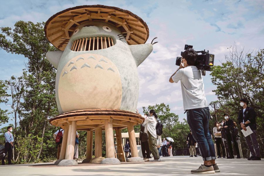 (FILES) This file photo taken on October 12, 2022 shows a member of the media taking video of an exhibit of Ghibli character 'Totoro' at Dondoko Forest during a media tour of the new Ghibli Park in Nagakute, Aichi prefecture. (Photo by Yuichi YAMAZAKI / AFP) 