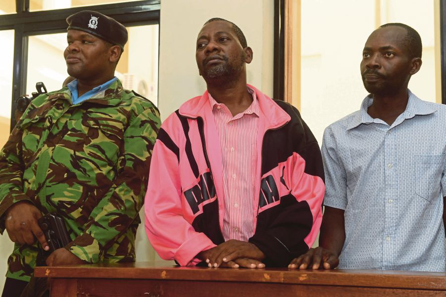 (FILES) Self-proclaimed pastor Paul Nthenge Mackenzie (centre), who set up the Good News International Church in 2003 and is accused of inciting cult followers to starve to death "to meet Jesus", appears in the dock with other co-accused at the court in Malindi. (Photo by SIMON MAINA / AFP)