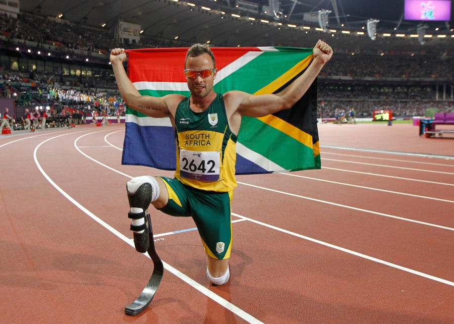 (FILES) South Africa's Oscar Pistorius poses with photographs with a national flag after winning gold in the men's 400m - T44 final during the athletics competition at the London 2012 Paralympic Games at the Olympic Stadium in east London. (Photo by IAN KINGTON / AFP)