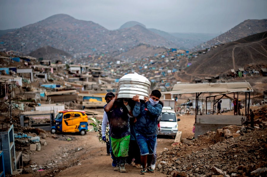 (FILES) In this file photo taken on May 30, 2020, relatives carry the coffin of a suspected COVID-19 victim at the Nueva Esperanza cemetery, one of the largest in Latin America, in the southern outskirts of Lima. - Latin America and the Caribbean on Dec 29 became the second region after Europe to top half a million deaths from Covid-19, according to an AFP count based on official tallies. (Photo by Ernesto BENAVIDES / AFP)