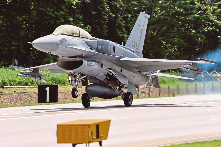 (FILES) A Republic of Singapore Air Force (RSAF) F-16 aircraft landing on a public road in Lim Chu Kang area during a media preview in Singapore. (Photo by ROSLAN RAHMAN / AFP)