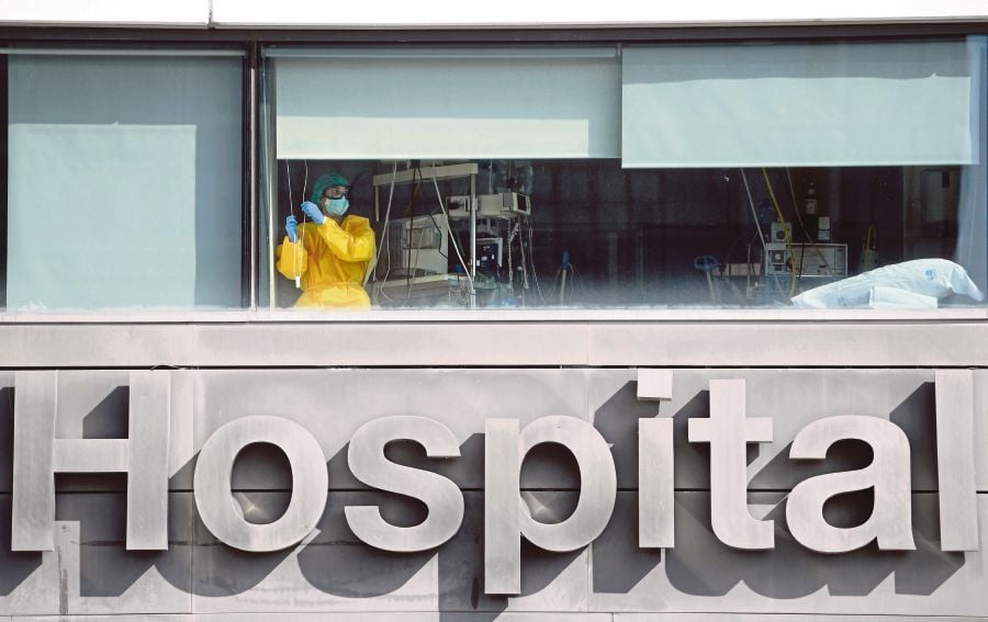 A healthcare worker wearing protective gear stands inside La Paz hospital in Madrid. - Spain surpassed one million virus cases yesterday according to health ministry figures. (Photo by PIERRE-PHILIPPE MARCOU / AFP)