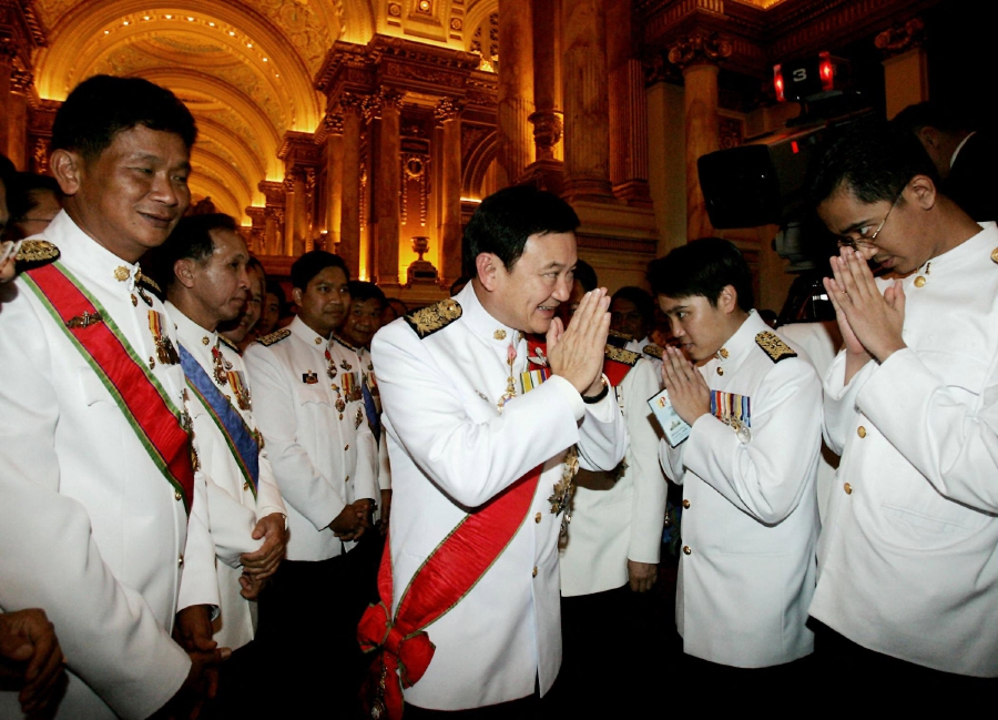 (FILES) Thailand's Prime Minister Thaksin Shinawatra (centre) is greeted by newly elected members of parliament from his Thai Rak Thai Party after his successful reelection campaign in Bangkok on March 4, 2005. (Photo by Saeed KHAN / AFP)