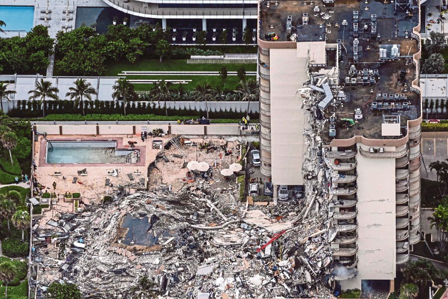 (FILES) In this file photo taken on June 24, 2021 an aerial view, shows search and rescue personnel working on site after the partial collapse of the Champlain Towers South in Surfside, north of Miami Beach. -  (Photo by CHANDAN KHANNA / AFP)