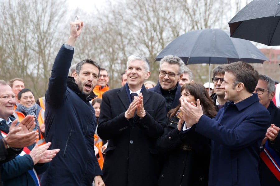 President of the Paris Organising Committee of the 2024 Olympic and Paralympic Games Tony Estanguet (L) reacts after he received the Olympic village key from General Manager of Solideo Nicolas Ferrand (C) next to Paris' Prefect Marc Guillaume (3rd R), Mayor of Paris Anne Hidalgo (2nd R) and France's President Emmanuel Macron (R) during the inauguration of the Paris 2024 Olympic village in Saint-Denis, northern Paris, on February 29, 2024. AFP PIC