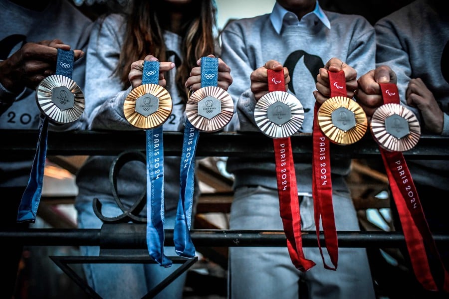 This picture shows upcoming Paris 2024 Olympics medals designed by Fench luxury jewellery house Chaumet, on February 01, 2024 during their presentation at the Eiffel tower in Paris. On the medals' head side, the engraved figures of the goddess of victory Athena, Nike, the Panathenaic stadium and the Acropolis are imposed by the International Olympic Committee (IOC) but Paris 2024 has obtained exceptional authorization to add the design of the Eiffel Tower, and use 18 grams of Eiffel Tower metal on each medal, extracted from pieces of the tower. AFP PIC