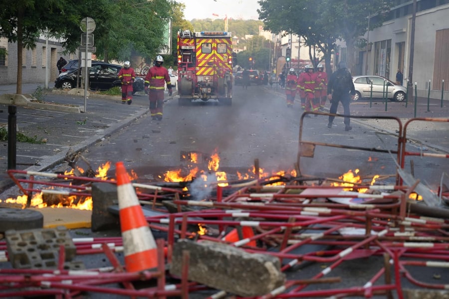 Firefighters arrive to put out fires after a demonstration in Nanterre, west of Paris, after French police killed a teenager who refused to stop for a traffic check in the city.  (Photo by Zakaria ABDELKAFI / AFP)