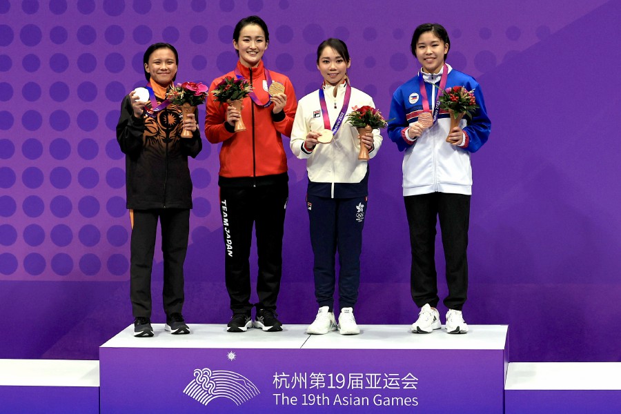 Gold medallist Japan's Kiyou Shimizu poses with silver medallist Malaysia's Lovelly Anne Robberth and bronze medallists Philippines' Sakura Alforte and Hong Kong's Lau Mo Sheung Grace during the medal ceremony for the Women's Individual Kata. -REUTERS PIC