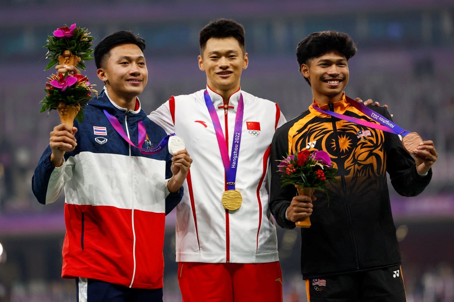 Gold medallist China's Zhenye Xie stands with Silver medallist Thailand's Puripol Boonson and bronze medallist Malaysia's Azeem Fahmi during the medal ceremony for the Men's 100m Final. -REUTERS PIC