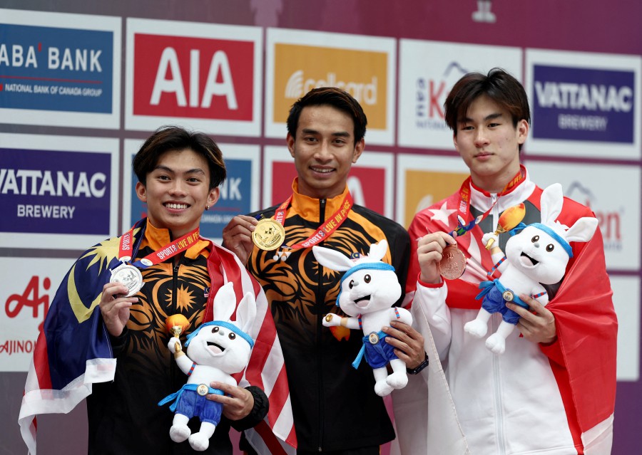 Gold medallist Muhammad Syafiq Puteh celebrates on the podium during the medal ceremony alongside silver medallist Gabriel Gilbert Daim and bronze medallist Singapore's Avvir Pac Lun Tham after the men's individual 3m springboard final. REUTERS PIC