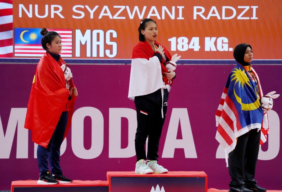 Gold medallist Indonesia's Tsabitha Alfiah Ramadani celebrates on the podium during the medal ceremony alongside silver medallist Vietnam's Thi Thu Uyen Dinh and bronze medallist Nur Syazwani Radzi after the women's - 64kg. -REUTERS PIC
