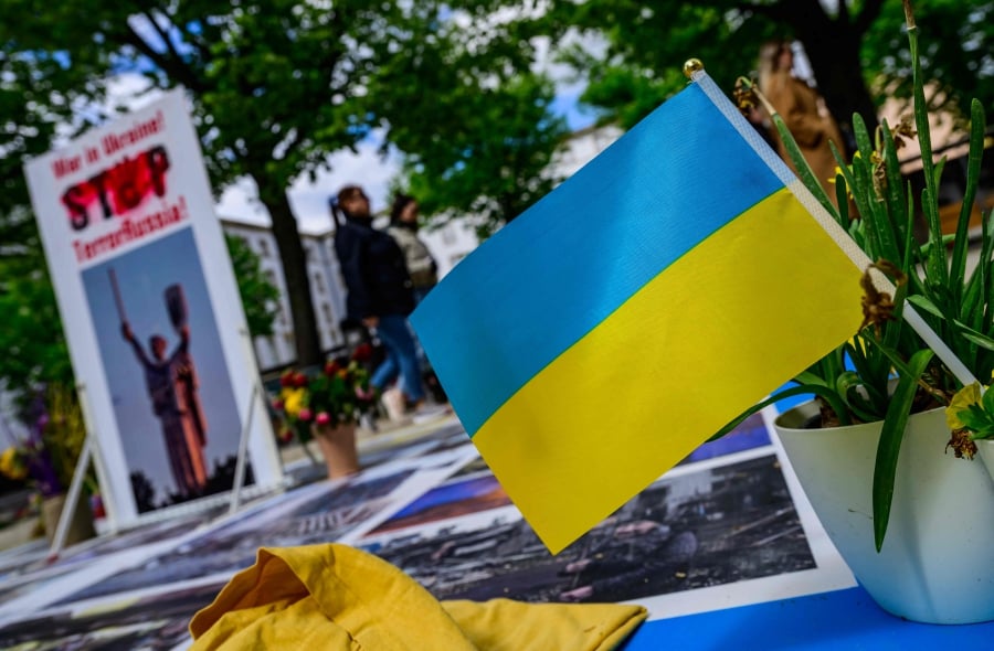 A Ukrainian flag flies at a makeshift memorial in front of the Russian embassy in Berlin dedicated to Ukrainian victims of the Russia-Ukraine conflict. (Photo by John MACDOUGALL / AFP)