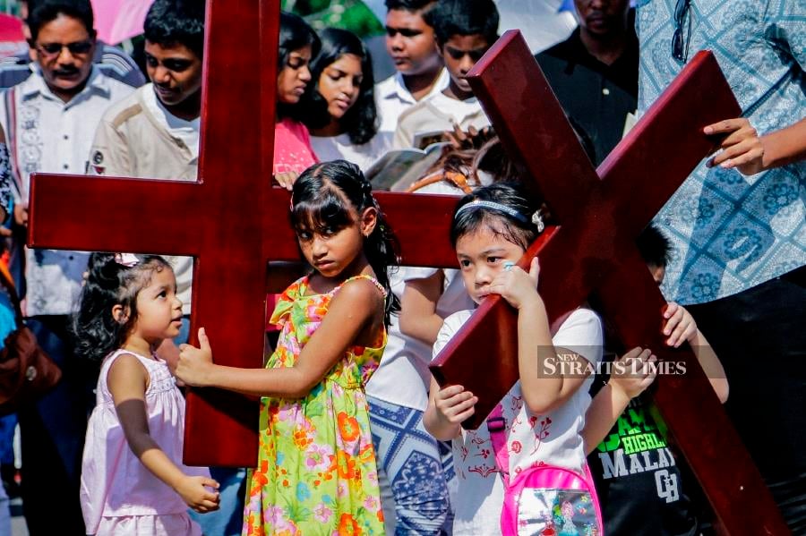 Children carry a wooden cross as they participating in the procession of Jesus's life in conjunction of Good Friday at the St. Francis of Assisi Church in Cheras. Pic by NSTP/AIZUDDIN SAAD