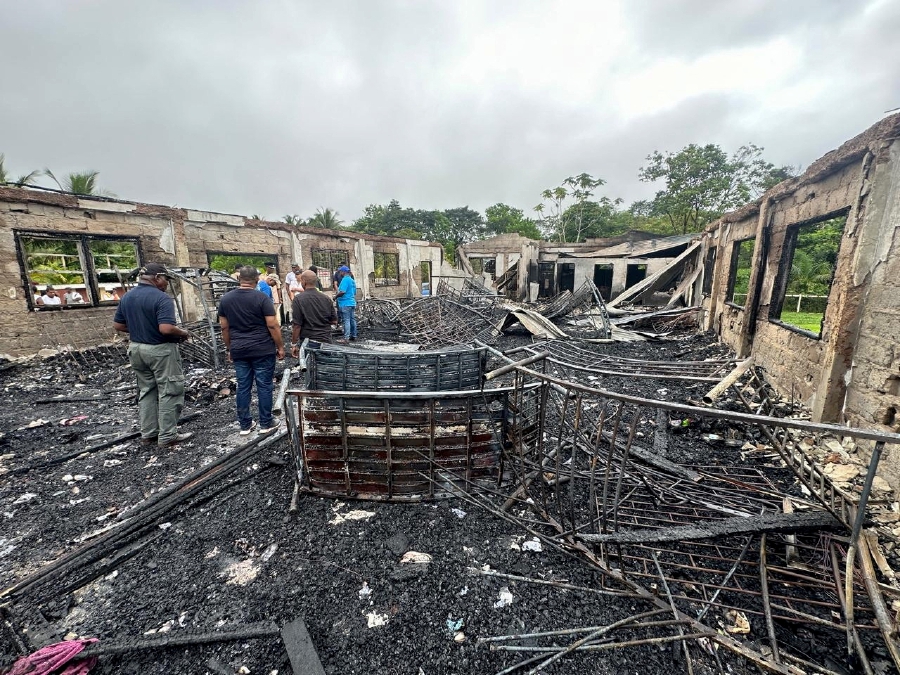 People stand inside the remains of a burnt secondary school dormitory after several children, most of them from indigenous communities, died after a fire gutted the building overnight, in Mahdia, Guyana. (Guyana Presidency/Handout via REUTERS)