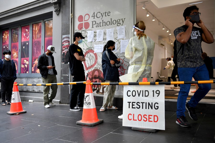 FILE PHOTO: People queue at a walk-in coronavirus disease (COVID-19) testing site in Melbourne, Australia. - AAP Image/Joel Carrett via REUTERS 