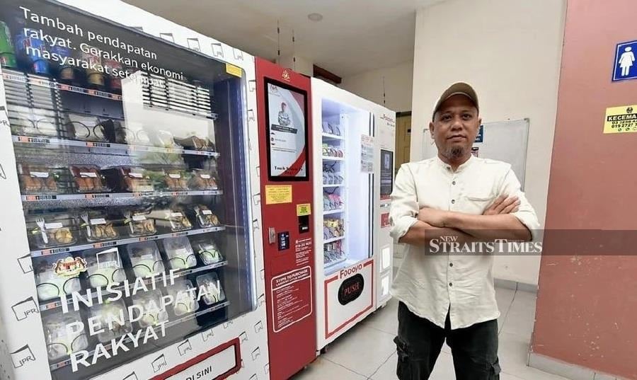 Mohd Hermi with his nasi kukus vending machine - BERNAMA PIC
