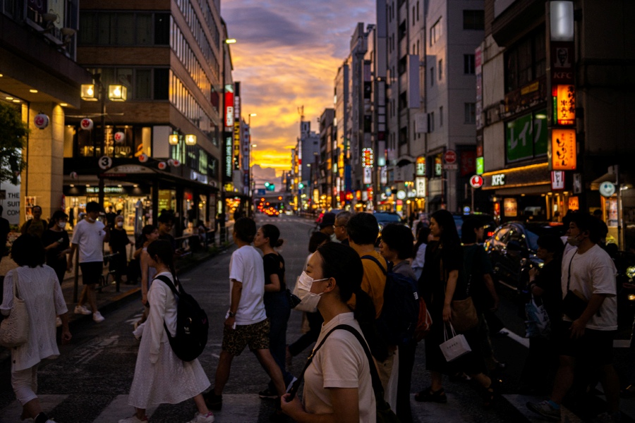 People stroll down a shopping street in Tokyo's Kichijoji area. (Photo by Philip FONG / AFP)