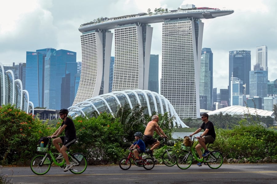 People cycling along Marina Bay East Park, past the Marina Bay Sands resort, in Singapore. -- AFP FILEPIC
