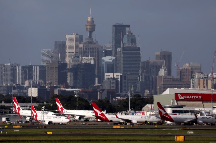 The Sydney central business district (CBD) behind Qantas Airways passenger aircraft parked at the Sydney domestic airport. - (Photo by DAVID GRAY / AFP)