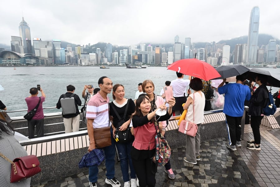 Tourists from mainland China visit the Tsim Sha Tsui waterfront in Hong Kong at the start of the Golden Week holiday period (Photo by Peter PARKS / AFP)