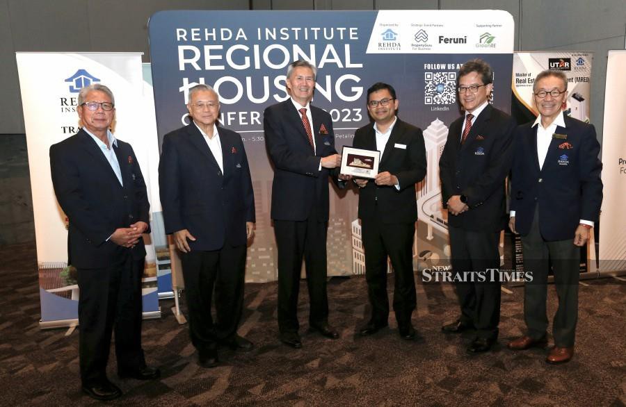 Deputy Minister of Local Government Development Akmal Nasrullah Mohd Nasir (4th from left) receiving a souvenir from chairman of REHDA Institute, Datuk Jeffrey Ng Tiong Lip (3rd from left) at the REHDA Institute Regional Housing Conference 2023 today. NSTP/ Amirudin Sahib