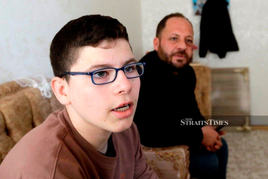 A resident of the IKataraj Orphanage, Hassan Al-Hassan 15, with his father, Abu Khalid Mohammad 38, who survived the earthquake, described the atmosphere of the earthquake that hit Belen, Turkiye. - NSTP/AIZUDDIN SAAD