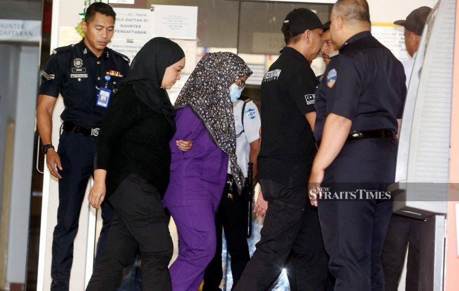 Zayn Rayyan Abdul Matiin's mother was escorted by the police after the case proceedings at the Petaling Jaya Magistrate's Court yesterday. - NSTP/HAIRUL ANUAR RAHIM