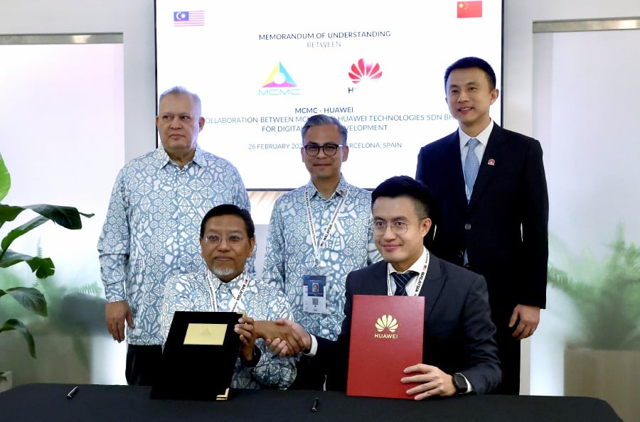 BARCELONA: Communications Minister Fahmi Fadzil witnessed the exchange of Memorandum of Understanding (MoU) documents signed by MCMC Chief Operating Officer Datuk Mohd Ali Hanafiah Mohd Yunus (seated, left) and Huawei Malaysia Vice President Zac Chow at the Mobile World Congress 2024 (MWC 2024) here today. Also present was the Chairman of the Malaysian Communications and Multimedia Commission (MCMC) Tan Sri Mohamad Salim Fateh Din. - Bernama pic