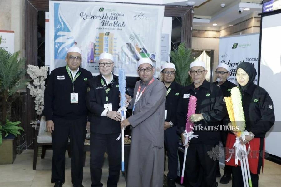Malaysian haj delegation head Datuk Seri Syed Saleh Syed Abdul Rahman (second from left) presenting a duster to a haj pilgrim.- Pic courtesy of Husain Jahit