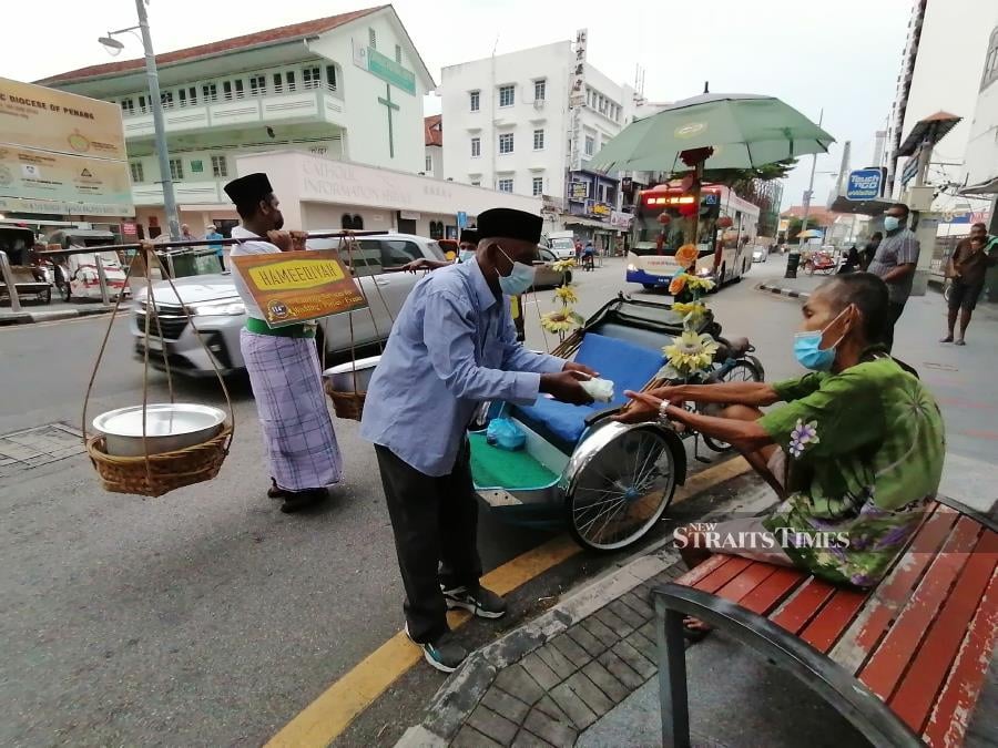 Aimed at bringing back the nostalgic feeling of days gone by, Restoran Hameediyah, believed to be the oldest nasi kandar restaurant in the country, distributed 250 packets of its specialty to the needy in a traditional way yesterday. - NSTP/ZUHAINY ZULKIFFLI