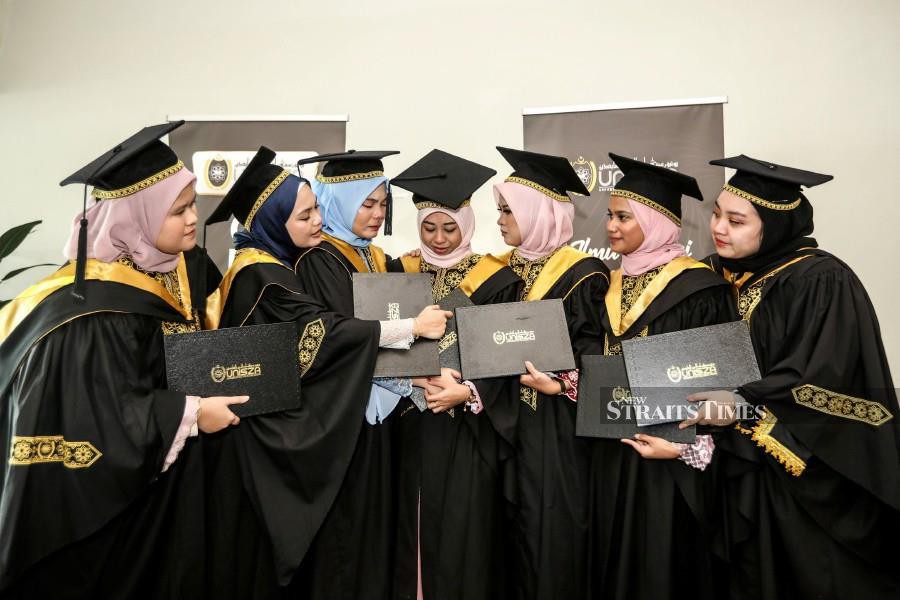 Haslina Kalang (centre) is seen with her friends after the convocation. -NSTP/GHAZALI KORI