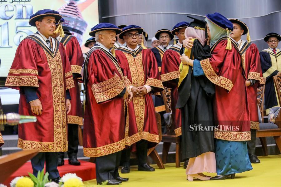 The university personnel is seen comforting Haslina Kalang (centre) before she receives her scroll during the convocation ceremony at Universiti Sultan Zainal Abidin (UniSZA), Gong Badak Campus in Kuala Nerus. - NSTP/GHAZALI KORI