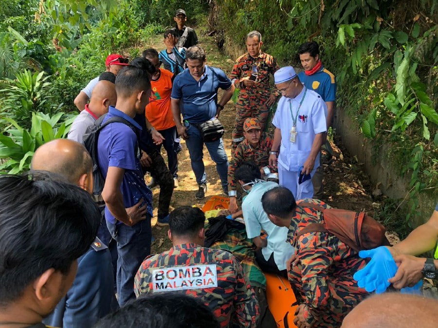 Firemen and medical officers checking a 39-year-old man who collapsed while descending Gunung Baling. He was confirmed dead at the scene. Picture courtesy of Fire and Rescue Department