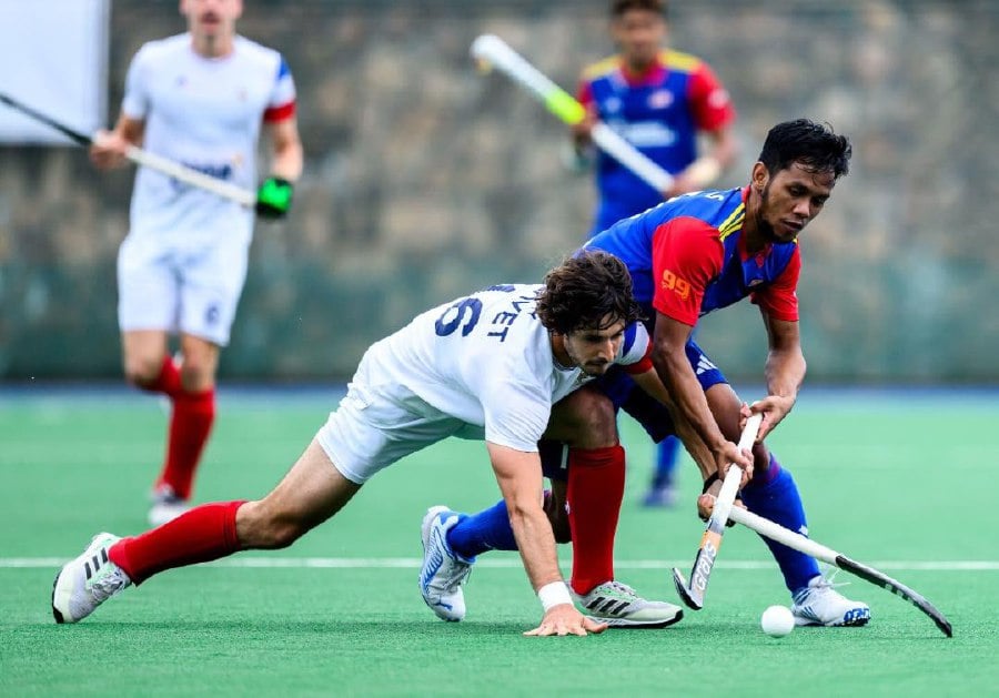 Malaysia's Faizal Saari tries to get the ball from a France player during a Nations Cup match in Gniezno, Poland, on Monday. - Pic courtesy from FIH
