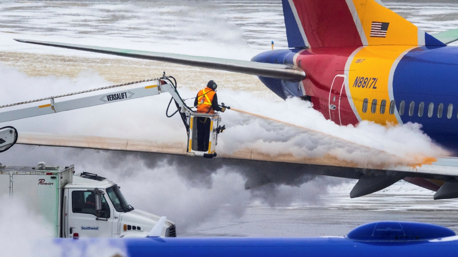 Crews deice a Southwest Airlines plane before takeoff in Omaha, Neb. An incoming winter storm threatens the Christmas travel rush. (Chris Machian/Omaha World-Herald via AP)