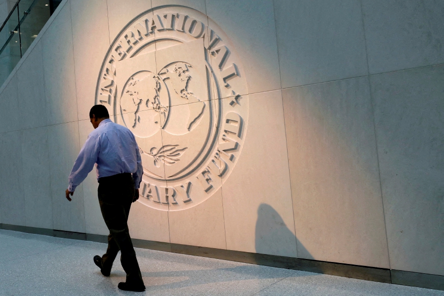 (FILE PHOTO) A man walks past the International Monetary Fund (IMF) logo at its headquarters in Washington, U.S. (REUTERS/Yuri Gripas/File Photo)