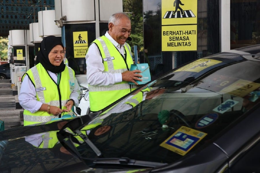 Anih Bhd chief executive officer Imran Gulcharan Abdullah distributing Chinese New Year goodies to highway users at the Gombak Toll Plaza today. -- Courtesy pic