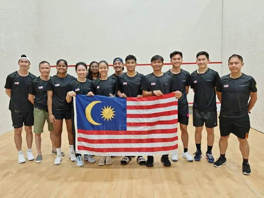 The Malaysian players pose with the national flag at the SEA Cup Squash Championships in Manila. PIC FROM SRAM