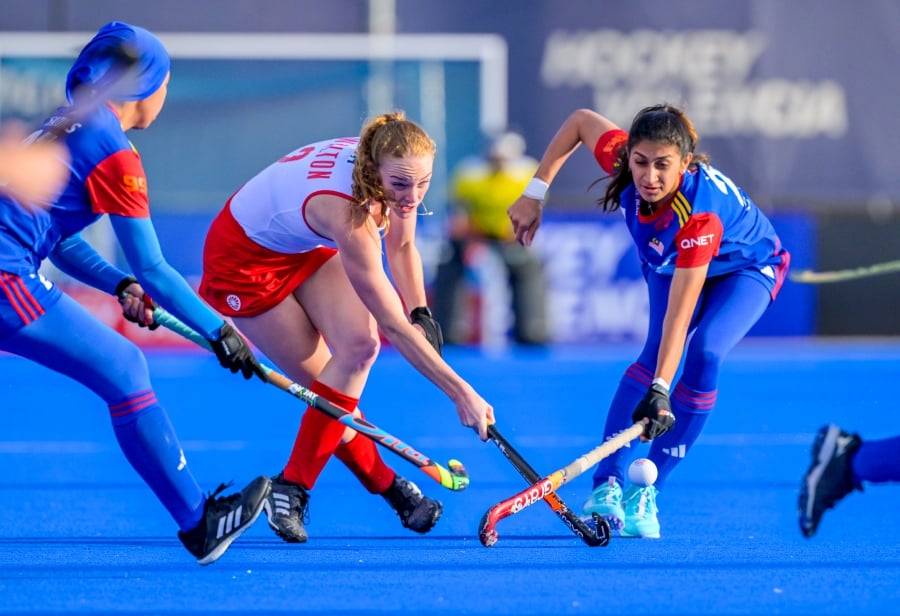 Malaysia (in blue) in action against Canada in Sunday’s Olympic Qualifier in Valencia, Spain. -- PIC FROM FIH