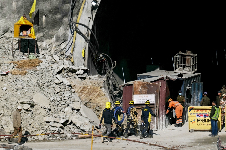 State Disaster Response Force (SDRF) personnel walk into the tunnel as rescue operation enters its final phase, to free workers trapped in the Silkyara under construction road tunnel, days after it a portion of it collapsed in the Uttarkashi district of India's Uttarakhand state. (Photo by Arun SANKAR / AFP)